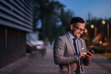 Man looking at his cell phone reviewing a new microlearning video