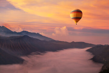 Hot air balloon over a cloudy mountain landscape