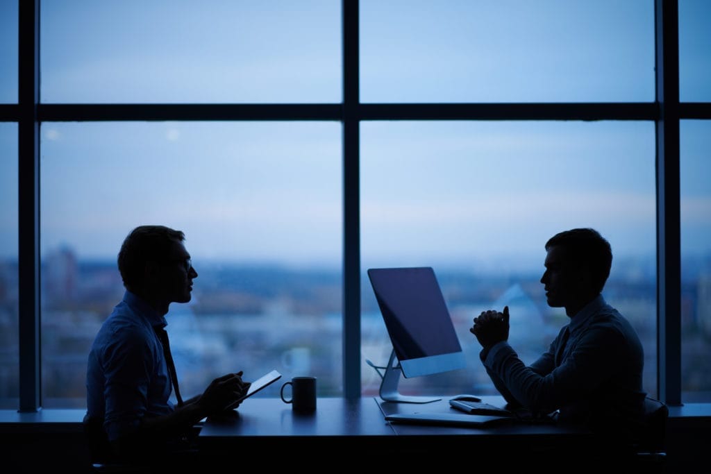 Two people discussing learning deployment requirements