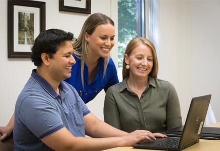 Three team members reviewing the latest eLearning development sample