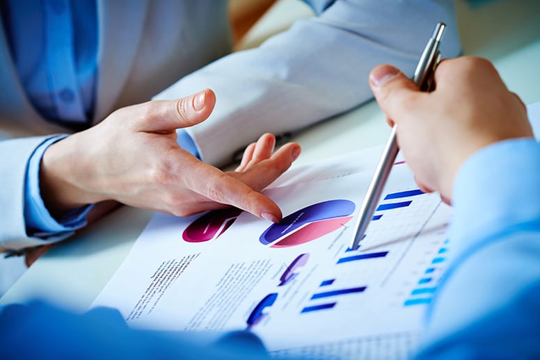 Close up of female and man's hands discussing a quarterly quality report